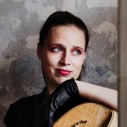 Eine Harfenistin blickt aus dem Fenster